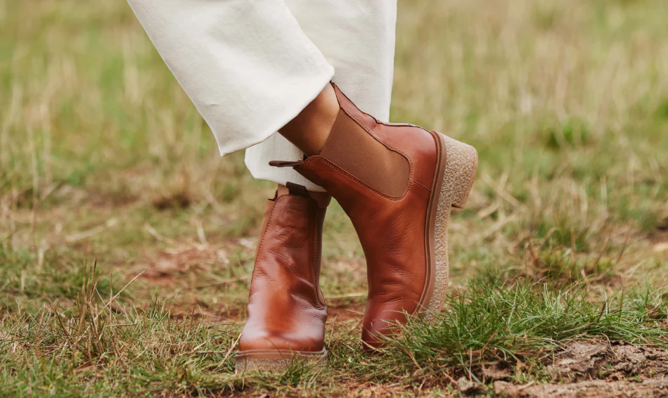 A pair of stylish angles fashion chelsea boots on a wooden floor