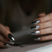 A close-up of a hand with a stylish, modern manicure featuring a popular fashion nail trend like chrome or minimalist art.