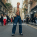 A stylishly dressed person confidently posing for a photo on the street during fashion week.