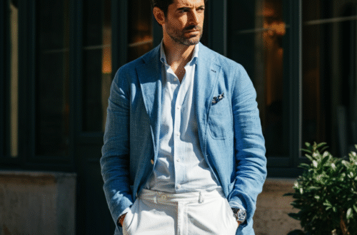 A stylishly dressed man in an unstructured blue blazer and white trousers, embodying classic Italian men's fashion.