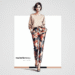 Melania Trump wearing a stylish outfit featuring tailored floral pants, paired with a solid-colored top and high heels.