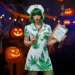 A person wearing a creative weed nurse costume with a green leaf theme, smiling at a Halloween party.