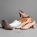 A stylish collection of different women's shoes in wide sizes, including heels, flats, and sneakers, arranged on a clean background.