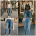 A woman wearing stylish daydreaming embellished straight leg jeans with pearl details, paired with a white top and heels in a bright, modern setting.