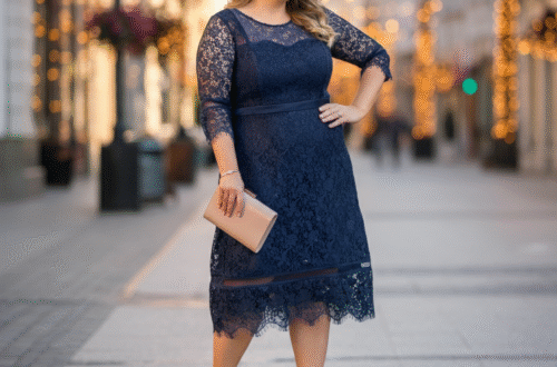 A woman wearing an elegant navy blue midi lace dress, smiling in a beautifully lit room.