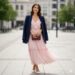Woman wearing elegant light pink colour dress with accessories for summer outdoor event